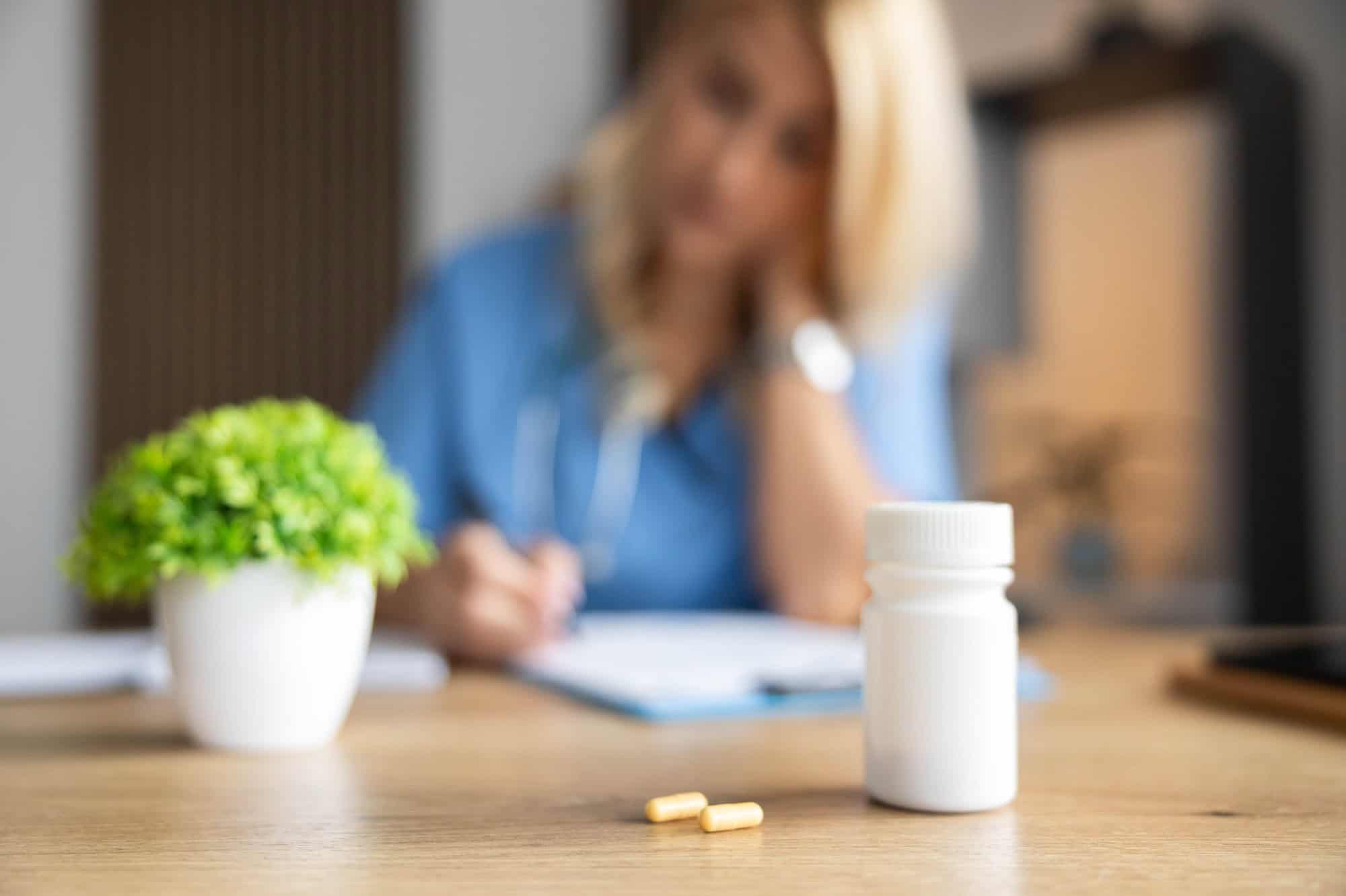 Person holding a medication bottle and pills while receiving mental health treatment in Bowling Green, KY at Redstone Behavioral Health.