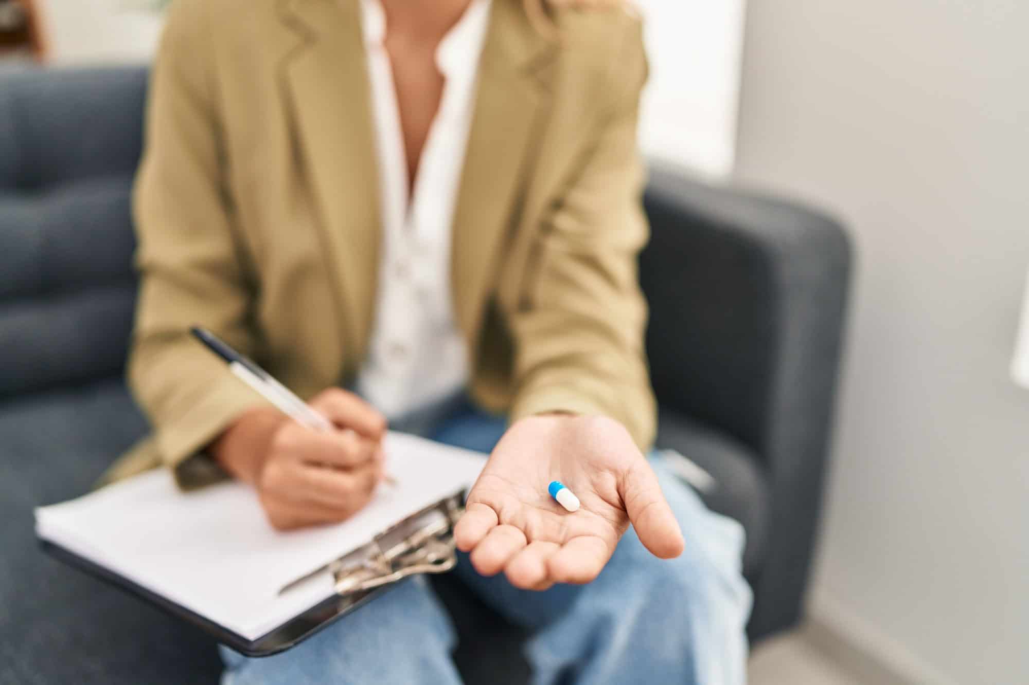 Therapist holding medication and a clipboard during a mental health treatment session in Bowling Green, KY at Redstone Behavioral Health.