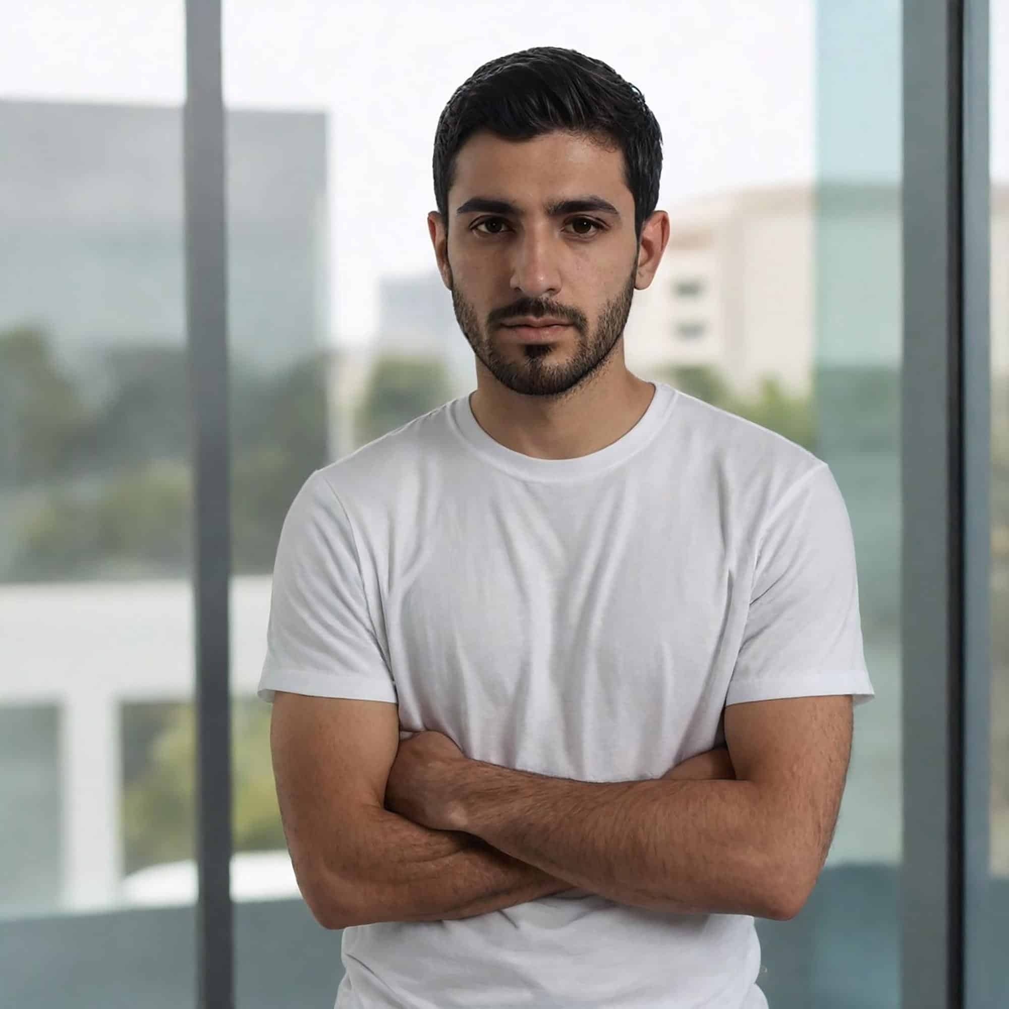 Young man with crossed arms in a modern office setting for behavioral health.